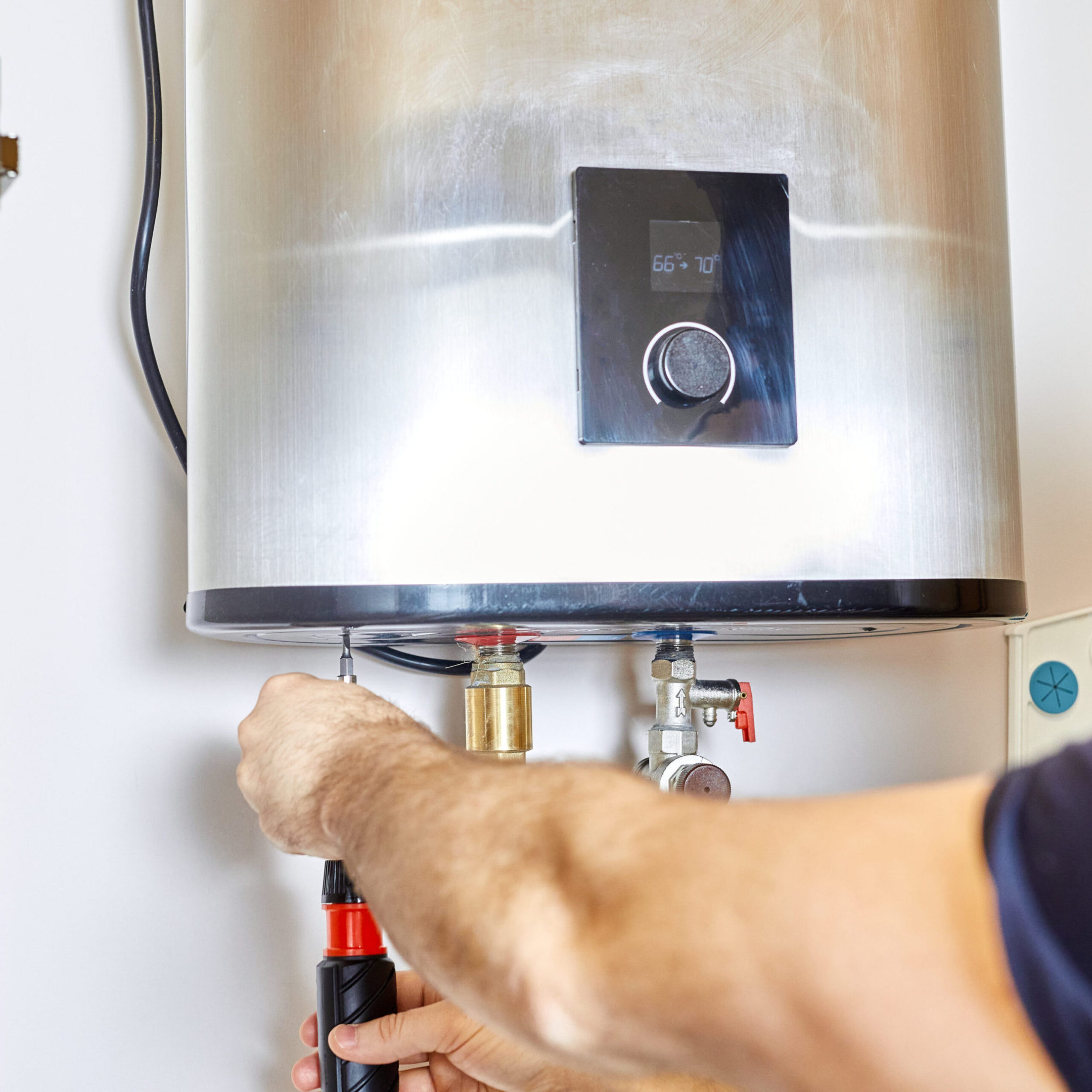 Man tightens the pipe nut in the water heating system. The master installs the water heater. The concept of bathroom maintenance.